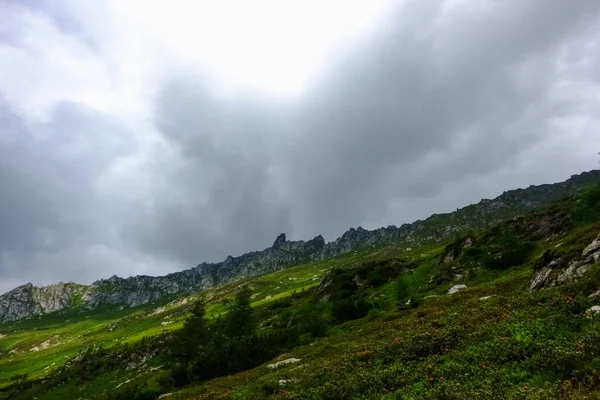 Косиста Зелена Гора Скелястими Горами Задньому Плані Дощовими Хмарами — стокове фото