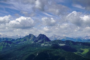 Gökyüzünde bulutlar olan harika bir manzarada dağlardan iki tepe.