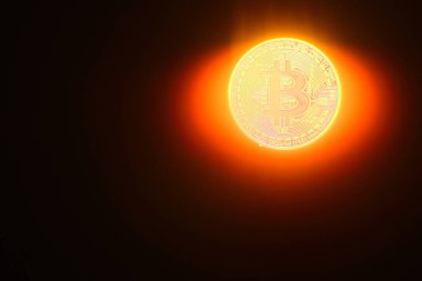 Parlak parlayan bitcoin yerine bir güneş ve siyah arkaplanda ışınlar