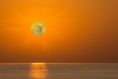 Güneş doğarken parlayan bitcoin yerine denizdeki küçük dalgalarla birlikte