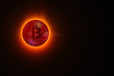 Kırmızı parlayan bitcoin yerine siyah arkaplan ile yanan bir güneş