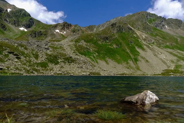 Grote Rots Het Water Van Een Bergmeer Tijdens Het Wandelen — Stockfoto