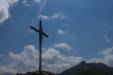 Zirve haçı bir dağda yürüyüş yaparken İsa heykeli ile birlikte.