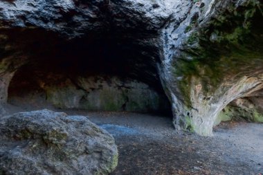 Dağlarda bir ormanda yürüyüş yaparken karanlık bir mağarada.