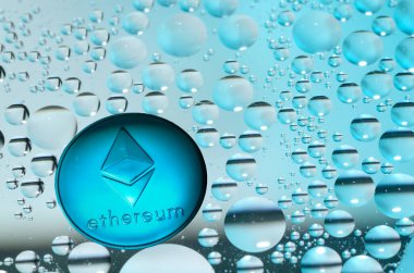 Mavi sudaki petrolün birçok halkası arasındaki etherden gelen madeni para