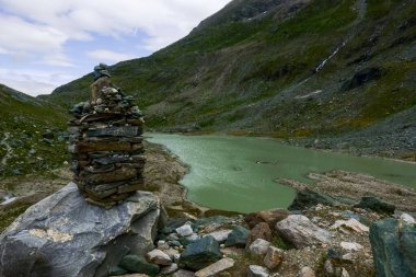 Avusturalya 'nın dağlarındaki yeşil bir gölde bir kayanın üzerine bir sürü taş yığıldı.