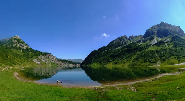 站在一个蓝山湖畔 从风景的全景中可以看到美丽的倒影 — 图库照片