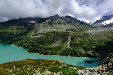 Dağlardaki turkuaz göl yürüyüş yaparken yukarıdan görünüyor.