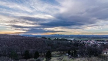 Gün batımında zaman kaybı ve gökyüzünde bulutlar olan dağlar.