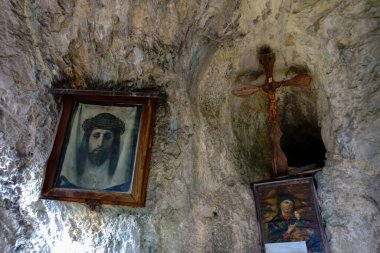 Dağlardaki eski bir mağarada İsa 'yla fotoğraf ve haçlar.