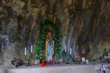 Dağlardaki dini kaleler arasında mumlar ve çiçeklerle dolu bir masa.