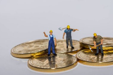 Altın parlayan bitcoin üzerinde çalışan madenciler. Gri arka planı olan kripto para birimi.