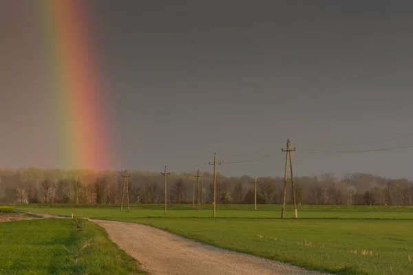 Prachtige Groene Velden Met Elektriciteitsmasten Een Regenboog Het Voorjaar — Stockfoto