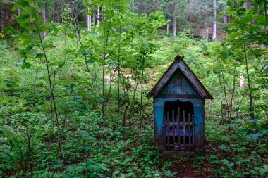 nice old wayside shrine in the green forest while hiking
