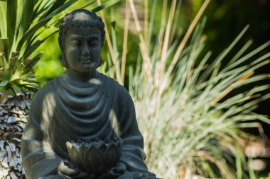 Palmiyeleri ve otları olan bir bahçede Buda figürü. Bali 'de tatildeki gibi.