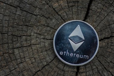 Ethereum kripto parasından tek bir gümüş eter sikke sağ ön taraftaki çatlamış bir ağaç gövdesinde duruyor.