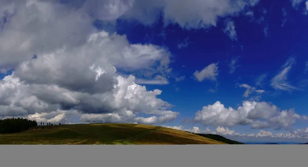 Wzgórze Różną Zielenią Trawy Niesamowite Chmury Błękitnym Niebie Widok Panoramy — Zdjęcie stockowe