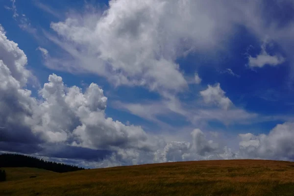 Prachtige Verschillende Wolken Een Blauwe Hemel Boven Een Heuvelachtige Berg — Stockfoto