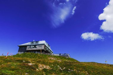 Dağdan zirveye yükselen alp kulübesinde yazları koyu mavi gökyüzü