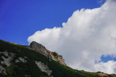 Avustralya 'daki harika bir dağın üzerinde derin mavi bir gökyüzünde büyük beyaz bir bulut.