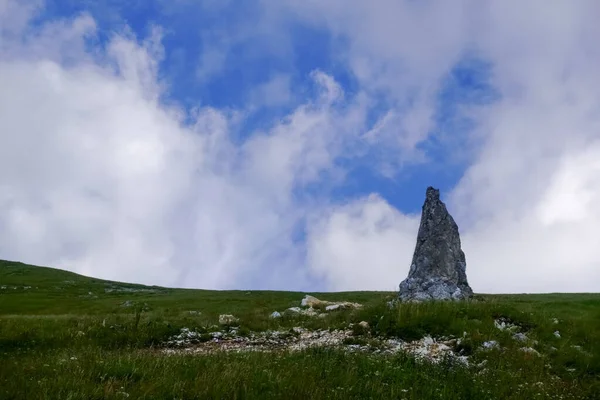 Singola Roccia Appuntita Prato Verde Con Nuvole Sul Cielo Blu — Foto Stock