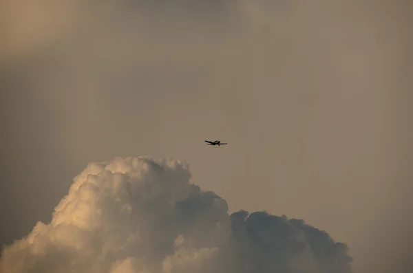 Small plane and larger cloud — Stock Photo, Image