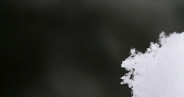 Wunderschöne Schneekristalle mit grau-schwarzem Panorama — Stockfoto