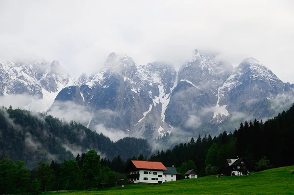 Dachstein met mist en huizen — Stockfoto