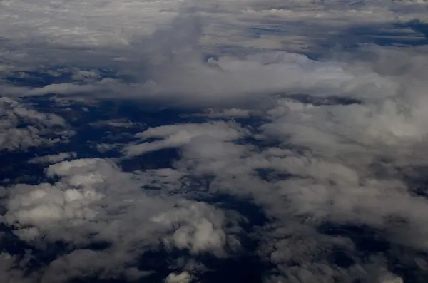 Muitas nuvens e país de avião — Fotografia de Stock