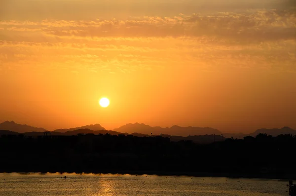 Belo pôr do sol quente com montanhas e mar — Fotografia de Stock