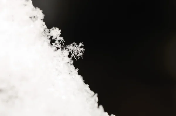 Snow crystal sloping snow on black — Stock Photo, Image