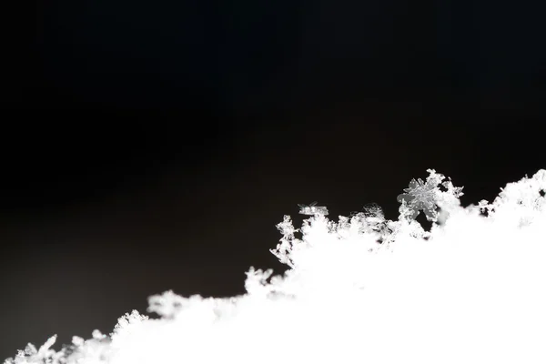 Kar kristalleri ve koyu arka plan — Stok fotoğraf