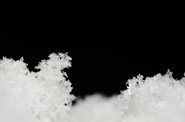 Fused snow and black background — Stock Photo, Image