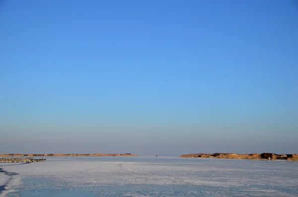 Frusen sjö med blå himmel — Stockfoto