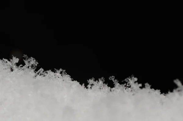 Пушистый снег на черном — стоковое фото