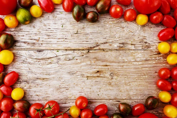 Frame of tomatoes family varieties over a wooden background — Stock Image Frame of tomatoes family varieties over a wooden background Stock Image