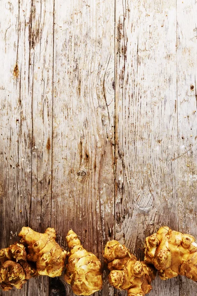 Topinambur orgânico fresco em fundo de madeira, articho de Jerusalém — Fotografia de Stock