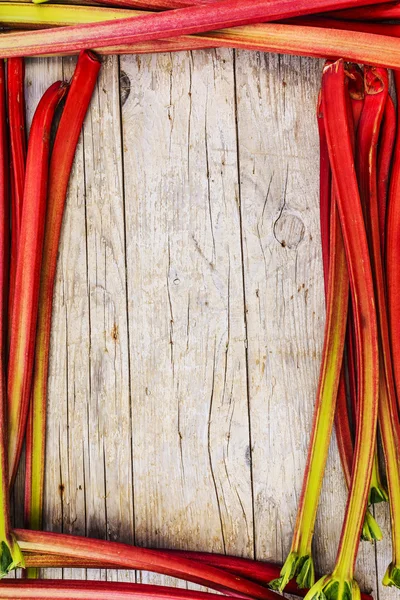 Rhubarb - fresh rhubarb on a wooden background, frame — Stock Photo, Image