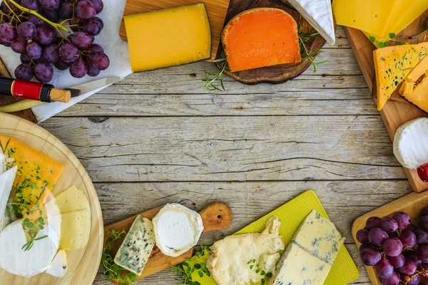Cheese - different types of cheese on a wooden background — Stock Photo, Image
