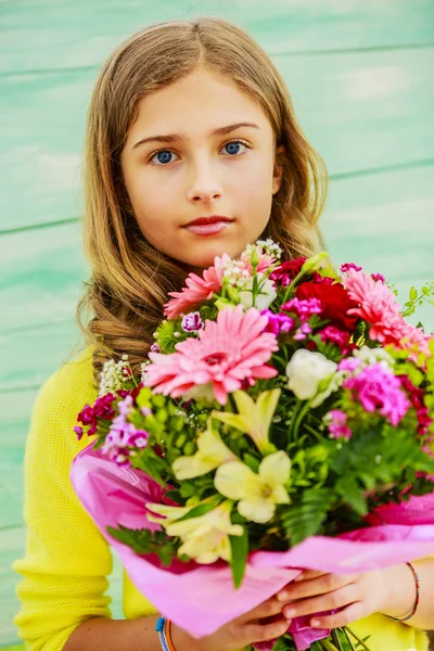 Mädchen mit einem Strauß bunter Blumen — Stockfoto