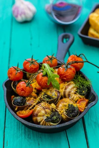 Baked escargot in butter with herbs and tomatoes — Stock Photo, Image