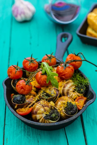 Escargot cozido na manteiga com ervas e tomates — Fotografia de Stock