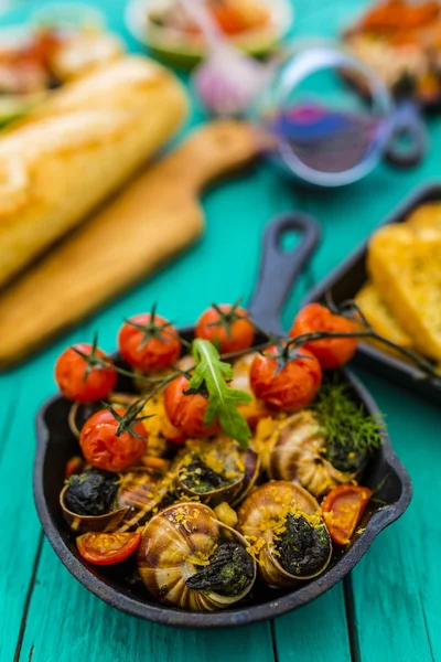 Escargot cozido na manteiga com ervas e tomates — Fotografia de Stock