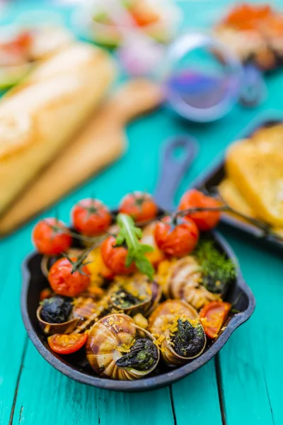 Escargot cozido na manteiga com ervas e tomates — Fotografia de Stock