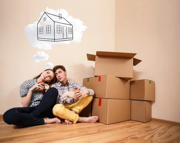 Young couple sitting on the floor and daydream — Stock Photo, Image