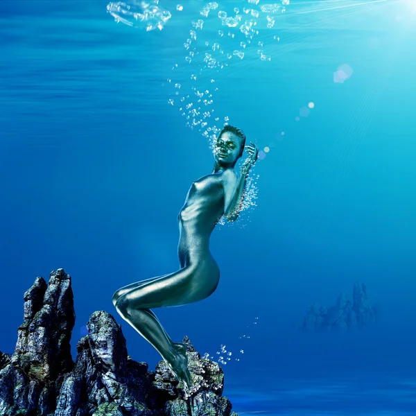 Mystisk kvinna med glansig hud under vattnet — Stockfoto