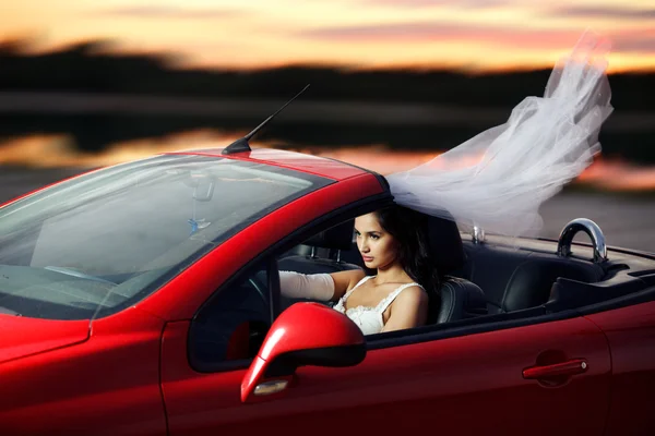 Novia sexual montando en un coche deportivo rojo — Foto de Stock