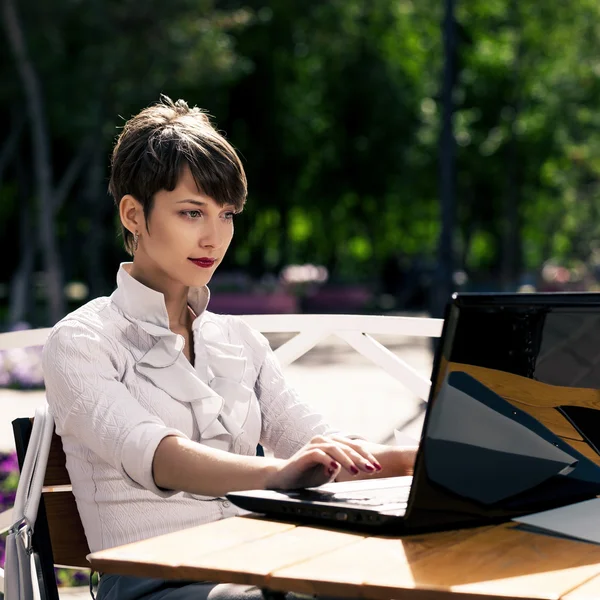 Atractiva mujer joven usando el ordenador portátil —  Fotos de Stock