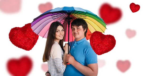 Szczęśliwy uśmiechający się para pod kolorowy parasol — Zdjęcie stockowe