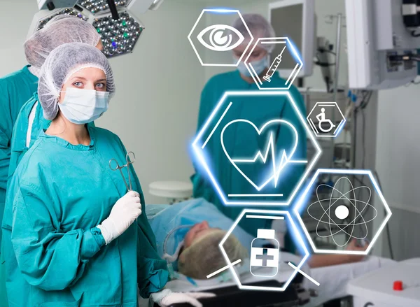 Equipe de cirurgia com ícones de saúde futuristas — Fotografia de Stock